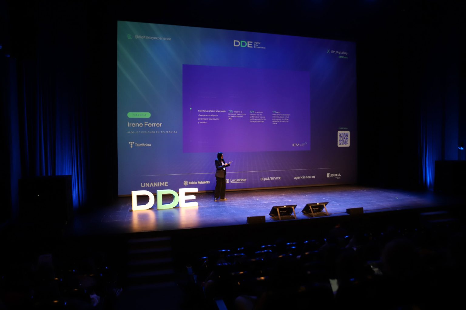 Irene Ferrer dando una charla en el escenario del Digital Day Experience 2024 de IEM, ante el público.