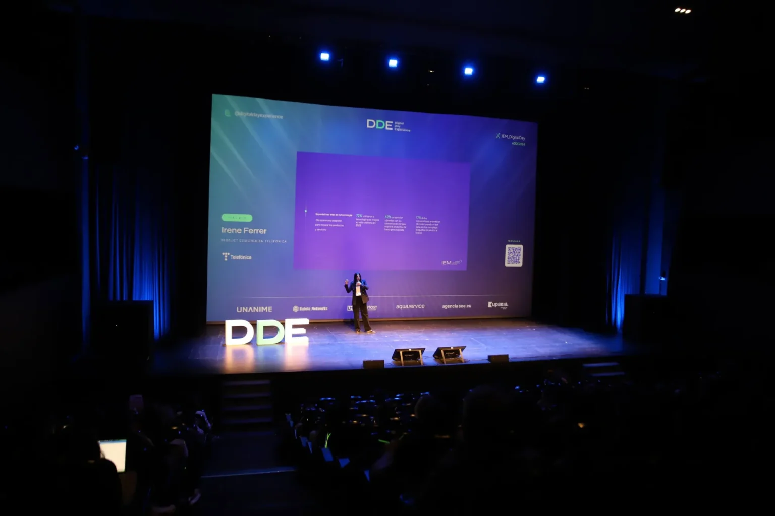 Irene Ferrer dando una charla en el escenario del Digital Day Experience 2024 de IEM, ante el público.