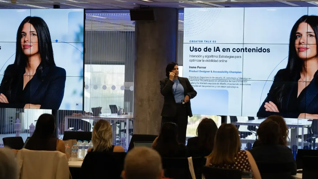 Irene Ferrer en el escenario de Telefónica Creators 2026 junto a la pantalla con el título de su charla «Uso de IA en contenidos».