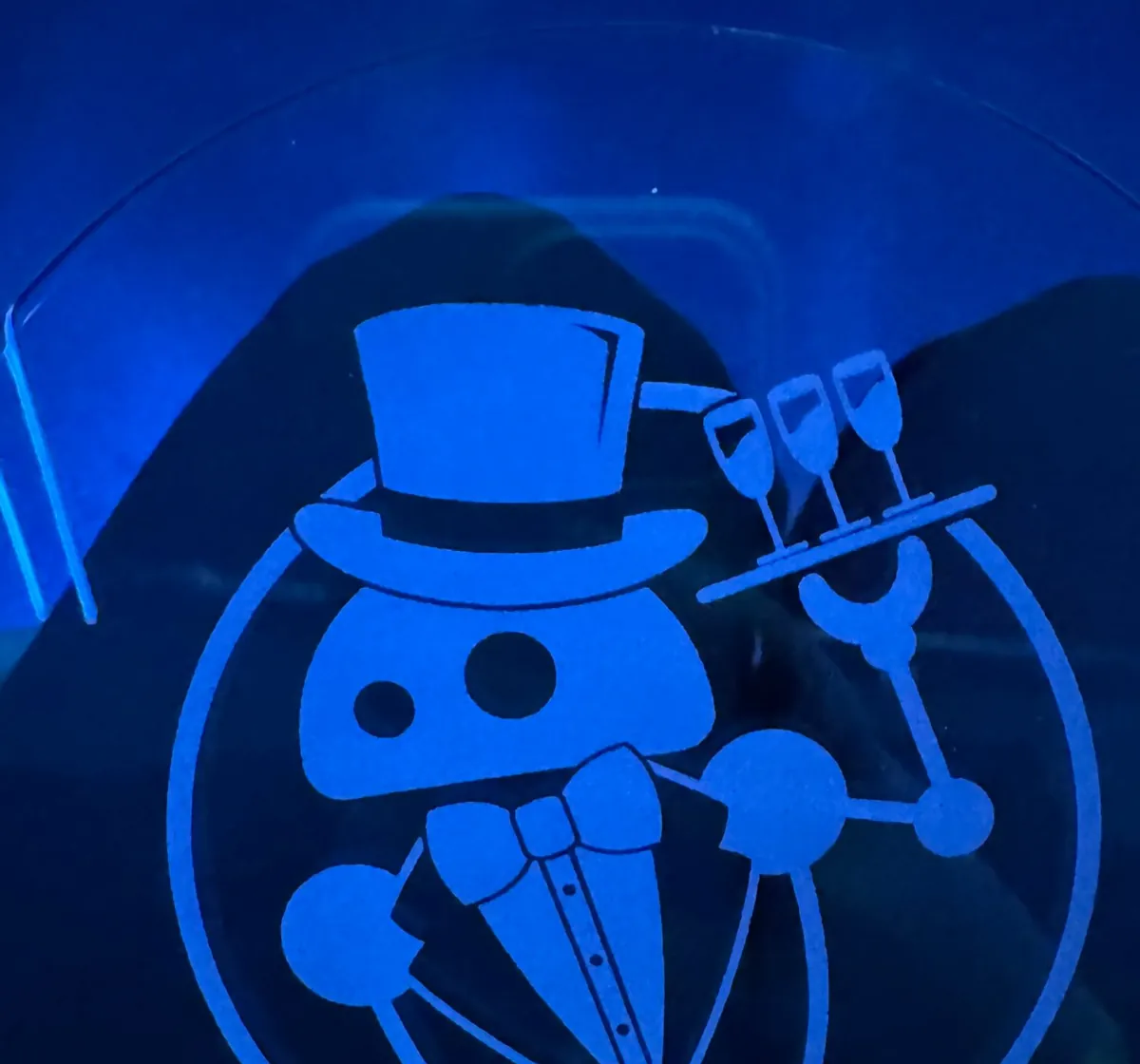 Trofeo de metacrilato de los Sirviendo Código Awards 2026 que recibió Irene Ferrer, con el logotipo grabado de un robot con chistera y una bandeja de copas.